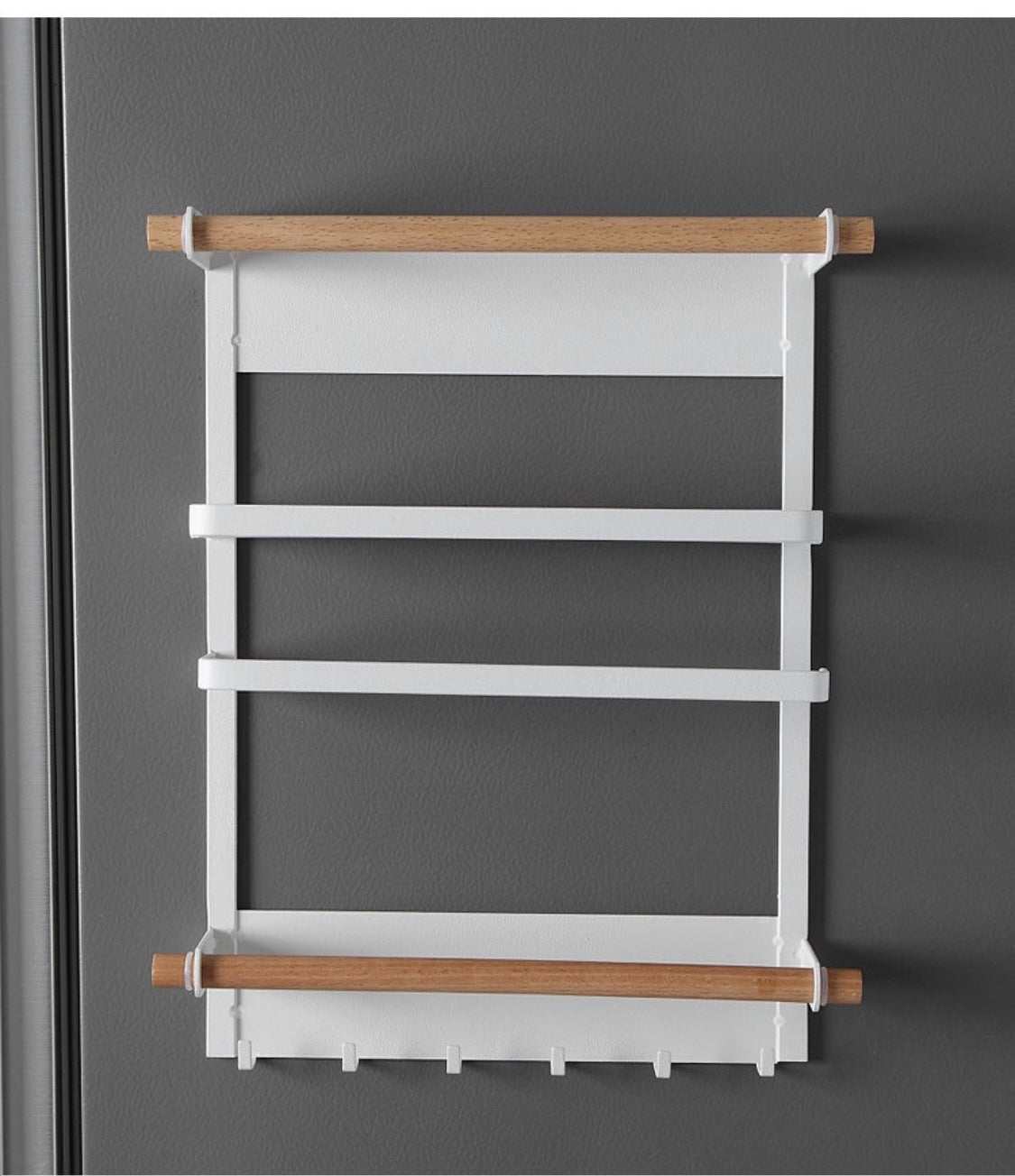 Magnetic kitchen towel rack and storage organizer mounted on refrigerator holding paper towels and spices